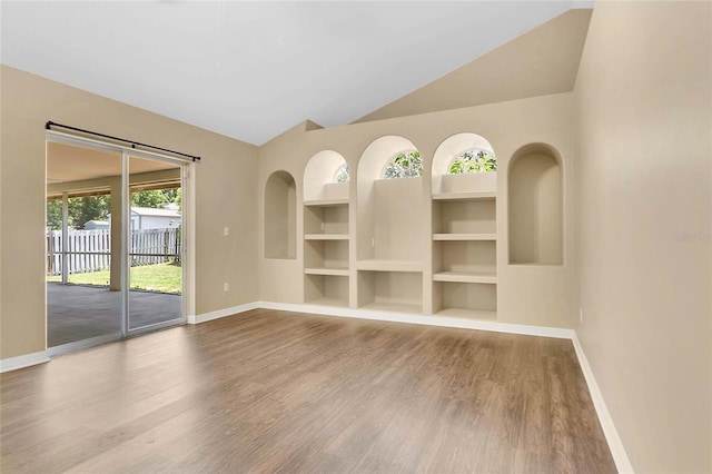 922 Hatteras Ave, Minneola, FL 34715 - empty room with baseboards, wood finished floors, built in features, and high vaulted ceiling