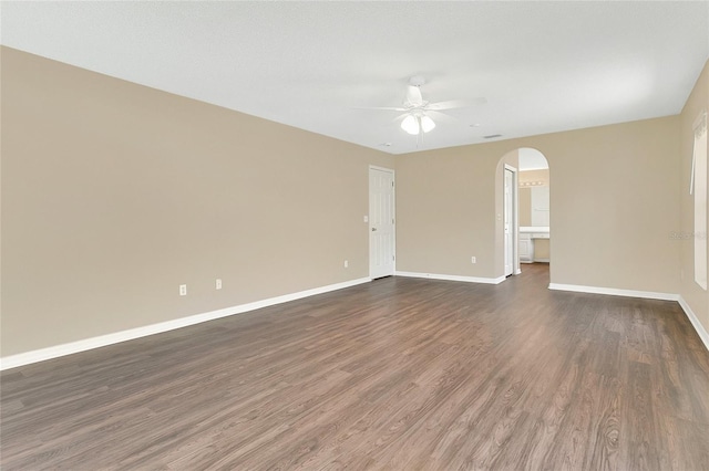 922 Hatteras Ave, Minneola, FL 34715 - empty room with ceiling fan, arched walkways, baseboards, and dark wood-style flooring