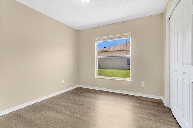 922 Hatteras Ave, Minneola, FL 34715 - unfurnished bedroom with wood finished floors, a closet, and baseboards