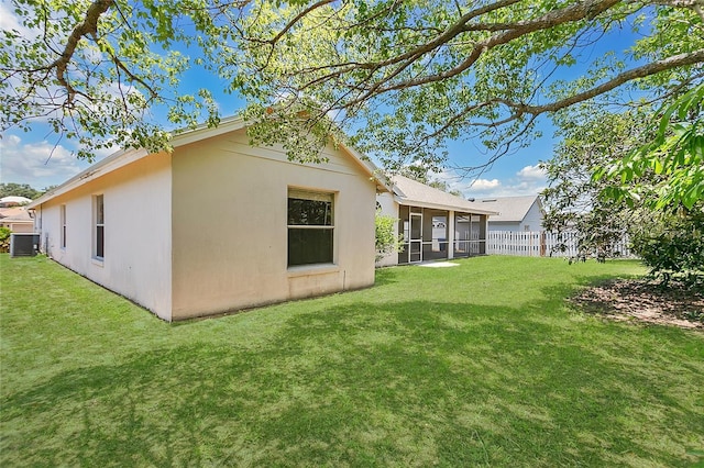 922 Hatteras Ave, Minneola, FL 34715 - rear view of property featuring a sunroom, central AC, and stucco siding