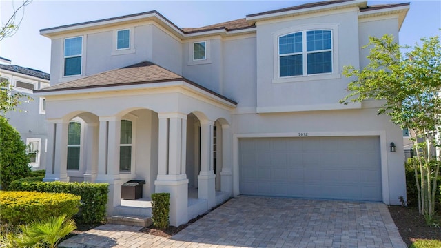 9038 Sunshine Ridge Loop, Kissimmee, FL 34747 - view of front of property with stucco siding, decorative driveway, an attached garage, and a porch
