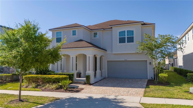9038 Sunshine Ridge Loop, Kissimmee, FL 34747 - mediterranean / spanish house featuring a garage, stucco siding, decorative driveway, and a porch