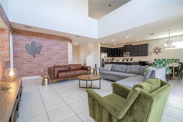 9038 Sunshine Ridge Loop, Kissimmee, FL 34747 - living area with light tile patterned floors, brick wall, a chandelier, and a high ceiling