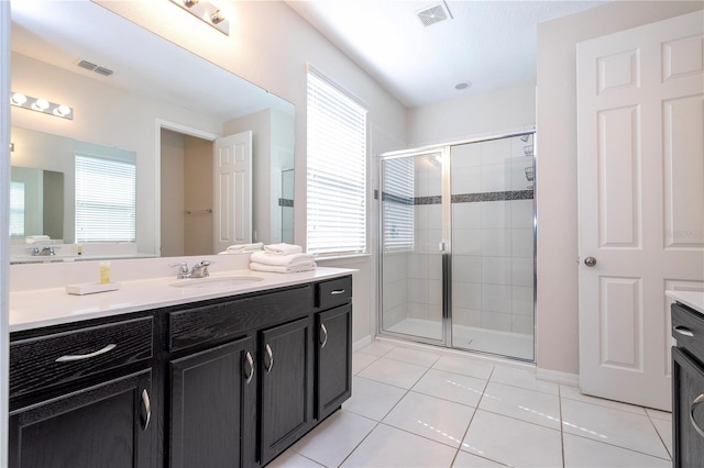 9038 Sunshine Ridge Loop, Kissimmee, FL 34747 - full bathroom featuring vanity, plenty of natural light, tile patterned flooring, and a shower stall