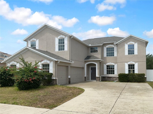 view of front of house featuring a garage, stucco siding, concrete driveway, and a shingled roof