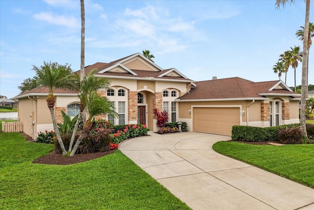 14174 Islamorada Dr, Orlando, FL 32837 - mediterranean / spanish house featuring stucco siding, a garage, a front lawn, driveway, and stone siding