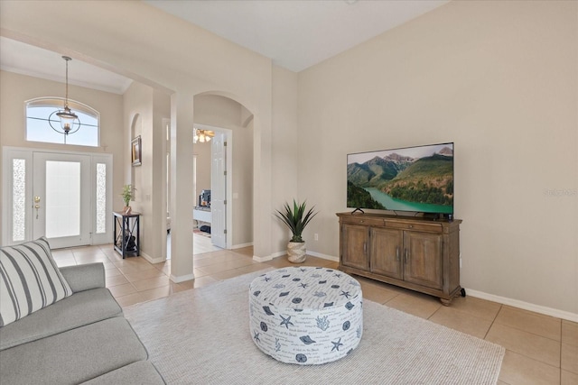 14174 Islamorada Dr, Orlando, FL 32837 - living area with light tile patterned floors, arched walkways, a towering ceiling, and baseboards