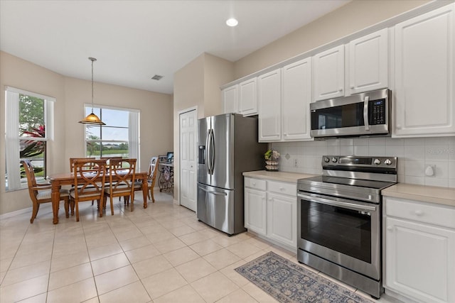 14174 Islamorada Dr, Orlando, FL 32837 - kitchen with stainless steel appliances, light countertops, decorative backsplash, and white cabinets
