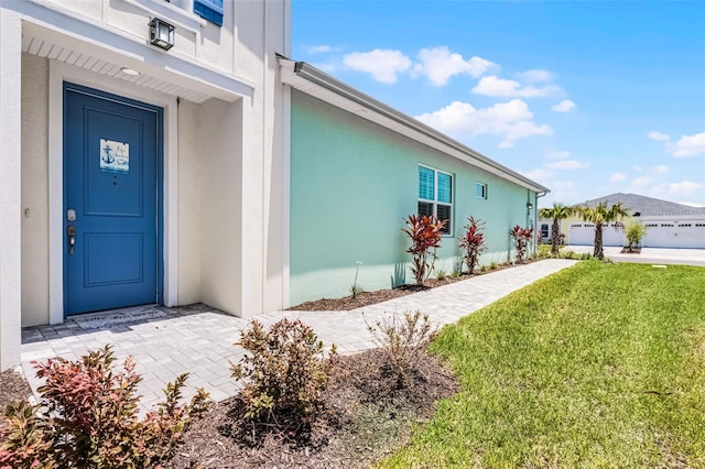867 Bama Breeze Dr, Daytona Beach, FL 32124 - property entrance with a yard and stucco siding