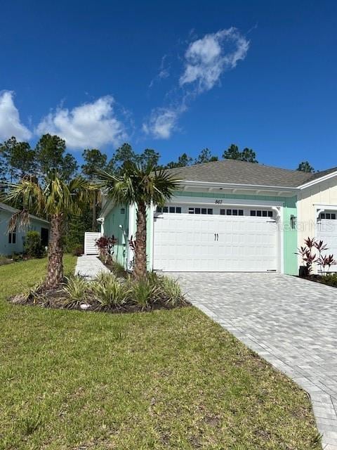 867 Bama Breeze Dr, Daytona Beach, FL 32124 - view of front of property featuring an attached garage, decorative driveway, and a front yard