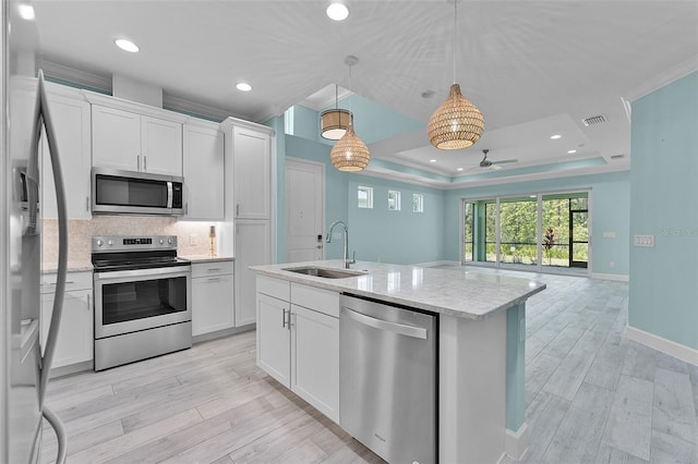 867 Bama Breeze Dr, Daytona Beach, FL 32124 - kitchen featuring appliances with stainless steel finishes, a sink, a raised ceiling, ceiling fan, and white cabinetry