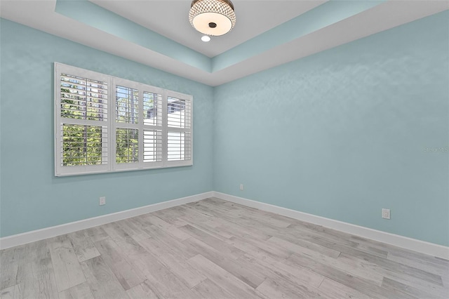 867 Bama Breeze Dr, Daytona Beach, FL 32124 - spare room featuring light wood finished floors, baseboards, and a tray ceiling