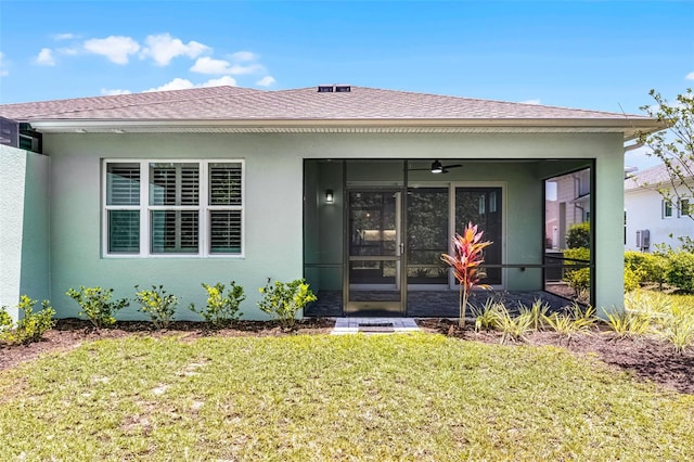 867 Bama Breeze Dr, Daytona Beach, FL 32124 - rear view of house featuring a yard, a sunroom, a ceiling fan, stucco siding, and a shingled roof