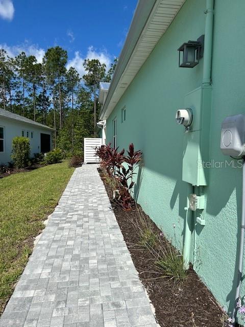867 Bama Breeze Dr, Daytona Beach, FL 32124 - view of home's exterior with stucco siding and a lawn