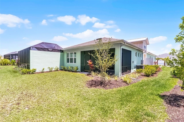867 Bama Breeze Dr, Daytona Beach, FL 32124 - rear view of property with a lawn, stucco siding, and a lanai