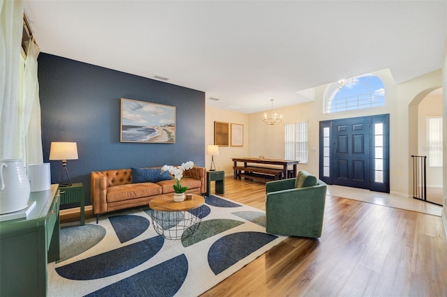 2956 White Cedar Cir, Kissimmee, FL 34741 - living room with a chandelier, wood finished floors, arched walkways, an accent wall, and baseboards