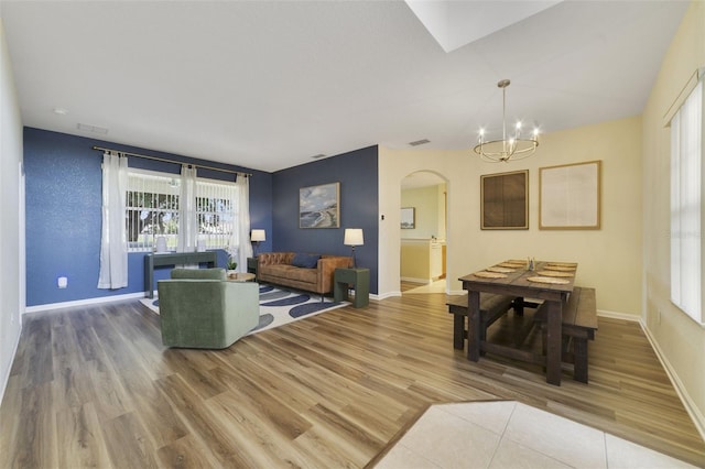 2956 White Cedar Cir, Kissimmee, FL 34741 - living room featuring arched walkways, wood finished floors, a chandelier, and baseboards
