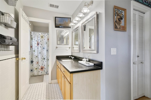 full bath featuring a closet, vanity, a shower with shower curtain, and baseboards