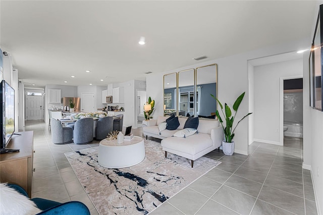 living room featuring light tile patterned floors, recessed lighting, and baseboards