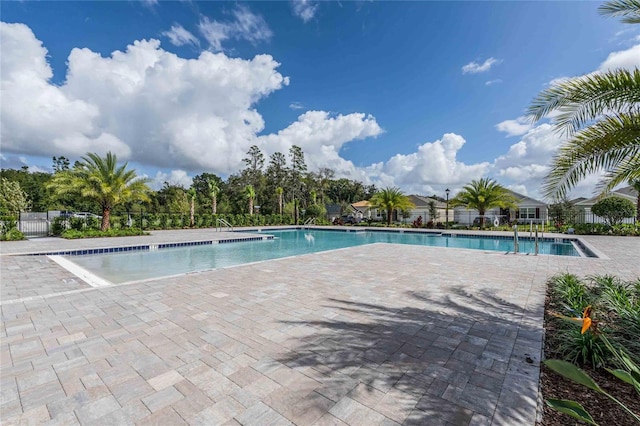 community pool with fence and a patio
