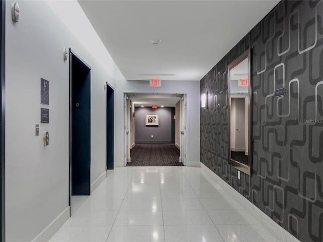 hallway featuring baseboards and elevator