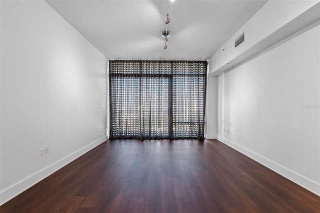 empty room featuring wood finished floors and baseboards