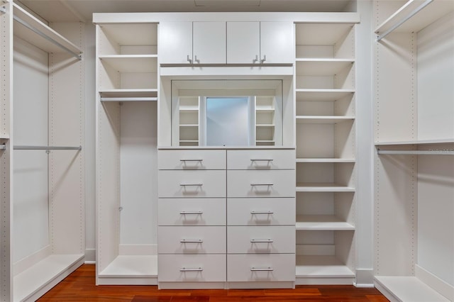 walk in closet with dark wood-style flooring