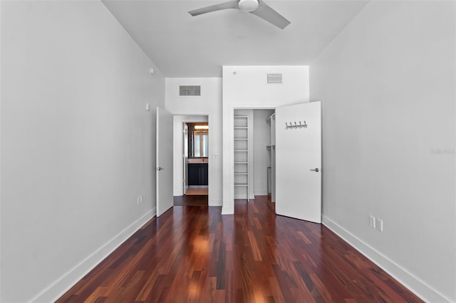 unfurnished bedroom with a closet, wood finished floors, and baseboards