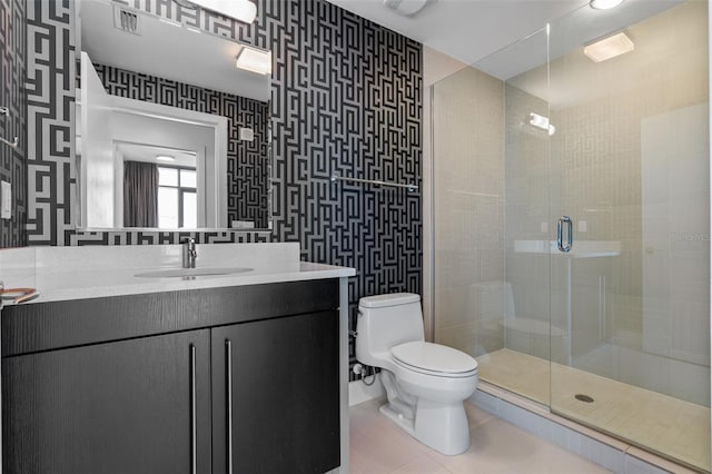 bathroom featuring a shower stall, toilet, vanity, tile patterned flooring, and wallpapered walls