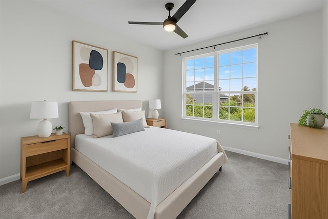 bedroom with light colored carpet, baseboards, and ceiling fan