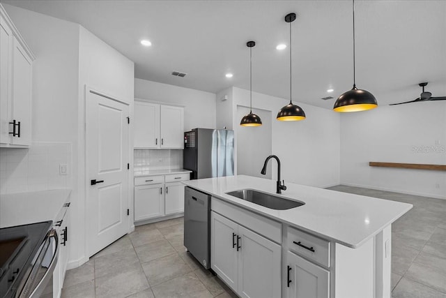 kitchen featuring stainless steel appliances, a sink, tasteful backsplash, light countertops, and recessed lighting