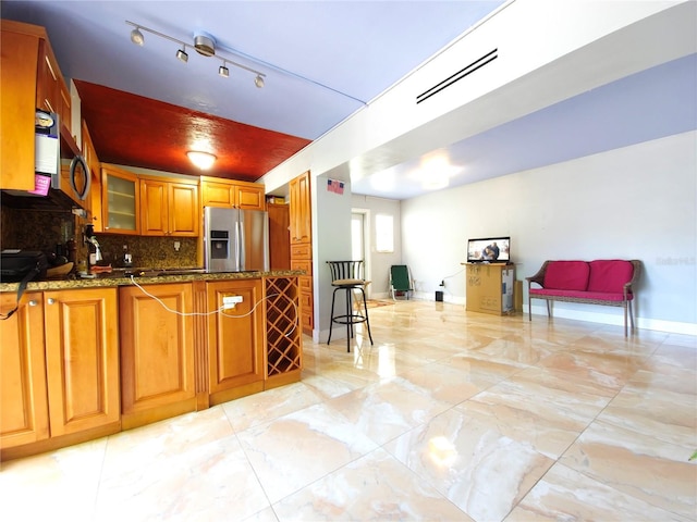 1820 James Ave Unit 2F, Miami Beach, FL 33139 - kitchen with stainless steel appliances, light marble finish floors, brown cabinets, glass insert cabinets, and backsplash
