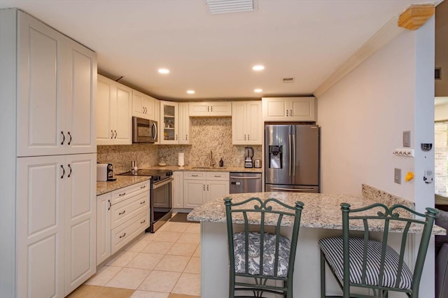 470 Oak Haven Dr Unit 470, Altamonte Springs, FL 32701 - kitchen with stainless steel appliances, a sink, a peninsula, light stone countertops, and recessed lighting