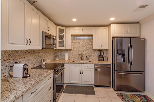 470 Oak Haven Dr Unit 470, Altamonte Springs, FL 32701 - kitchen featuring appliances with stainless steel finishes, a sink, white cabinetry, tasteful backsplash, and light stone countertops