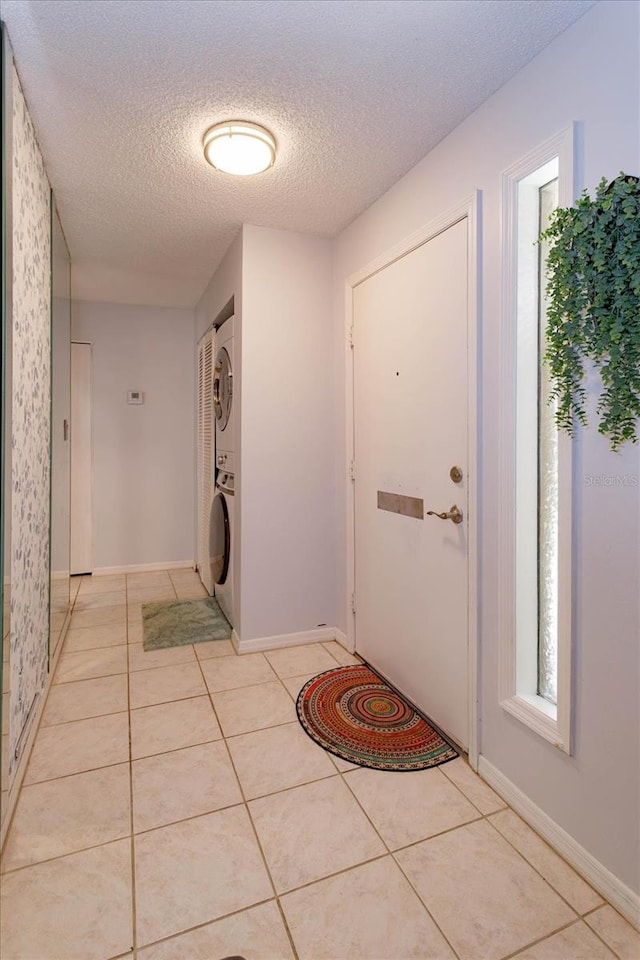 470 Oak Haven Dr Unit 470, Altamonte Springs, FL 32701 - foyer with stacked washing machine and dryer, a textured ceiling, light tile patterned floors, and baseboards