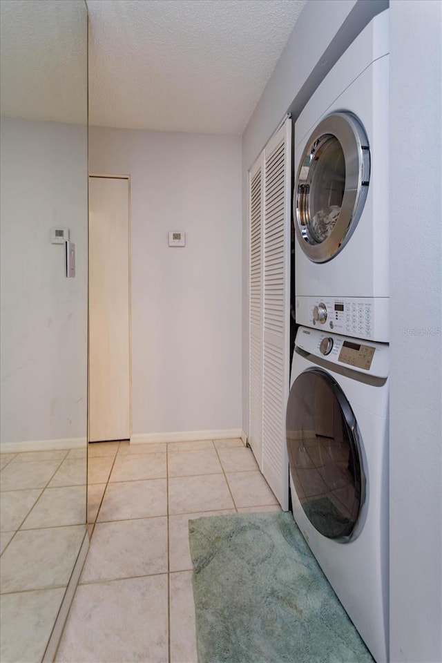 470 Oak Haven Dr Unit 470, Altamonte Springs, FL 32701 - laundry area with stacked washing machine and dryer, light tile patterned floors, a textured ceiling, and baseboards