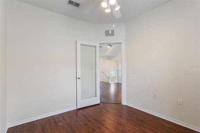 empty room with wood finished floors, a ceiling fan, and baseboards