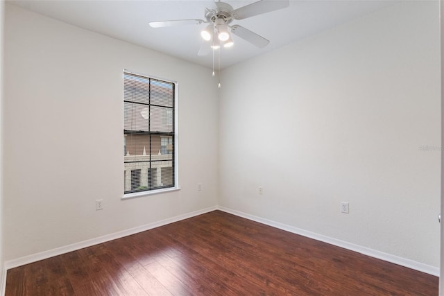 unfurnished room featuring dark wood finished floors, baseboards, and a ceiling fan
