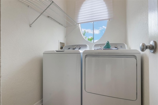 laundry area featuring washer and clothes dryer and a textured wall