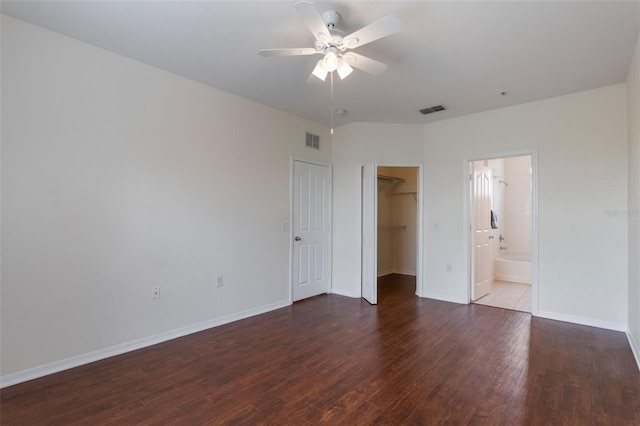 unfurnished bedroom with wood finished floors, baseboards, a spacious closet, a closet, and ceiling fan