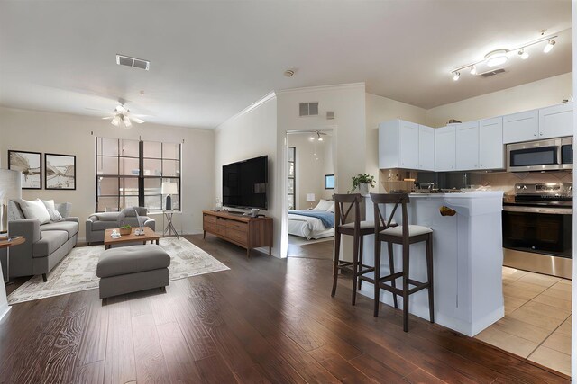 6107 Metrowest Blvd Unit 104, Orlando, FL 32835 - living room with a ceiling fan, dark wood-style floors, and crown molding