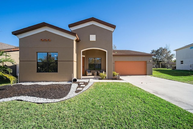 view of front facade with stucco siding, a garage, concrete driveway, and a front yard