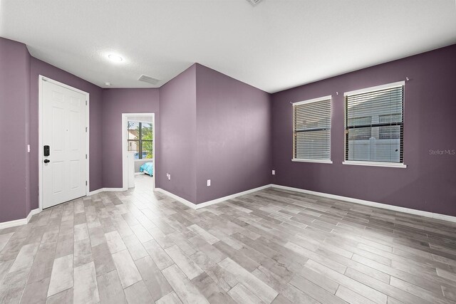 unfurnished room with light wood finished floors and baseboards