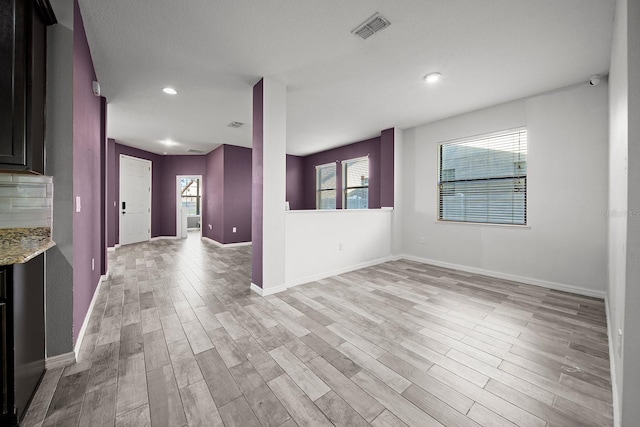 empty room with light wood finished floors, baseboards, and recessed lighting