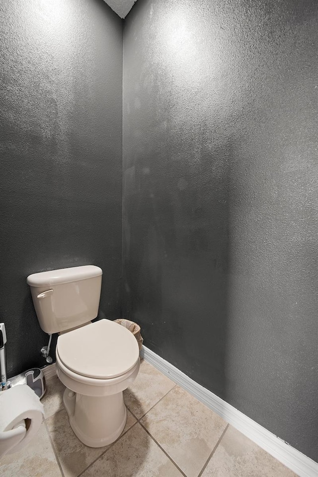 bathroom with toilet, tile patterned floors, and baseboards