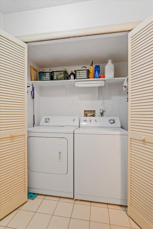 3987 Lancashire Ln Unit 3987, Longwood, FL 32779 - laundry area with washer and dryer, light tile patterned floors, and a textured ceiling