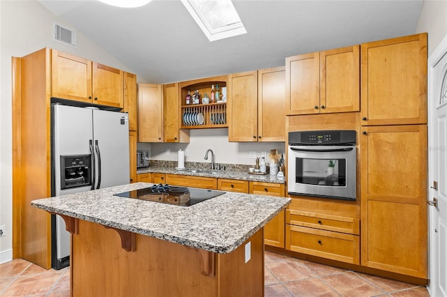 kitchen with oven, fridge with ice dispenser, black electric stovetop, a sink, and a kitchen island