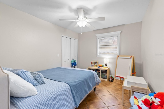 bedroom with tile patterned floors, a closet, ceiling fan, and baseboards