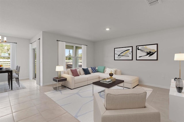 living room with healthy amount of natural light, light tile patterned floors, a chandelier, and recessed lighting