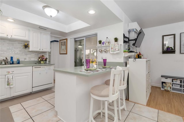 1804 W Shores Rd, Melbourne, FL 32935 - kitchen featuring dishwasher, a sink, white cabinetry, a kitchen breakfast bar, and recessed lighting